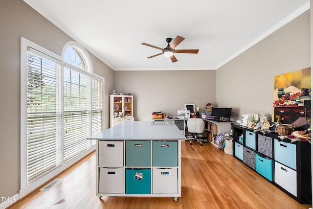 office area featuring light wood finished floors, visible vents, ornamental molding, and ceiling fan