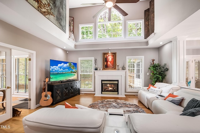 living area with a fireplace with flush hearth, a high ceiling, and wood finished floors