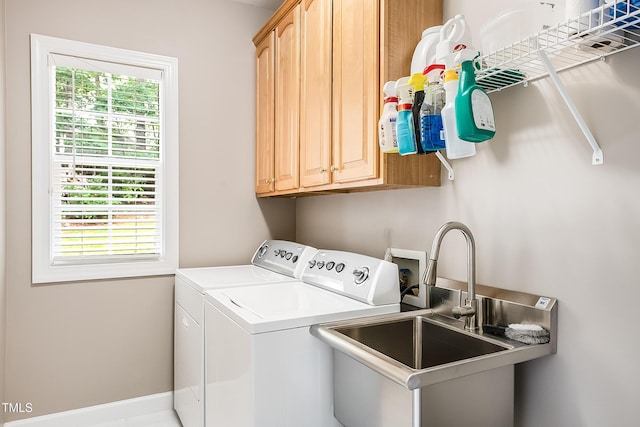 laundry room featuring a wealth of natural light, washer and dryer, cabinet space, and a sink