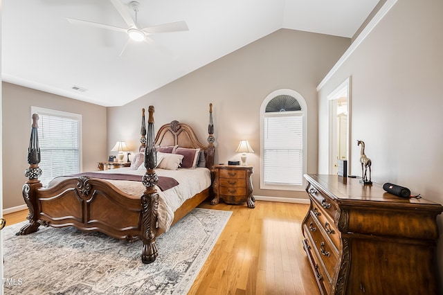 bedroom featuring ceiling fan, visible vents, baseboards, vaulted ceiling, and light wood-type flooring