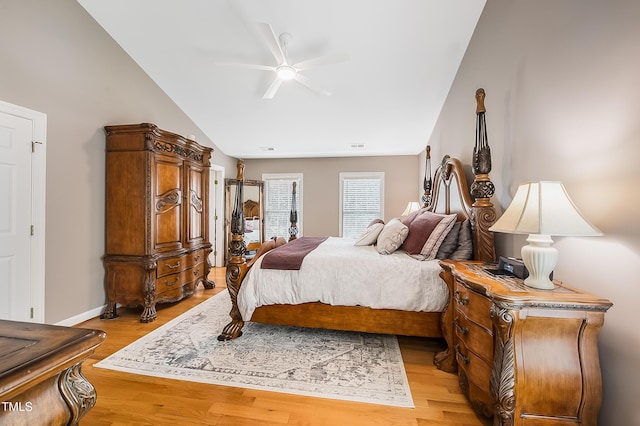 bedroom featuring lofted ceiling, baseboards, visible vents, and light wood finished floors