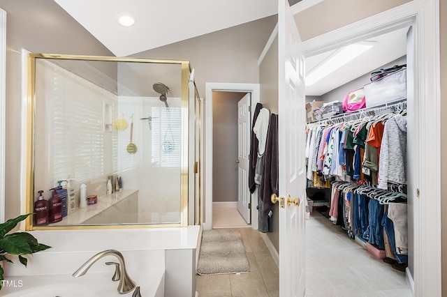 full bath with tile patterned flooring, a shower stall, a walk in closet, and a sink