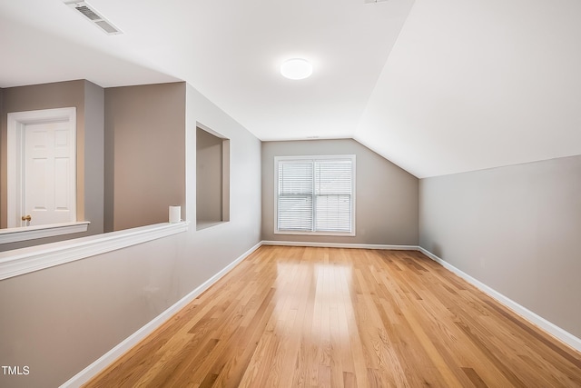 bonus room with vaulted ceiling, light wood-type flooring, visible vents, and baseboards