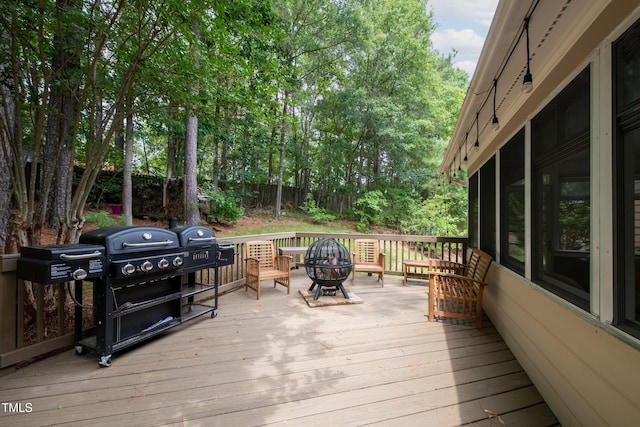 deck featuring an outdoor fire pit, area for grilling, and fence