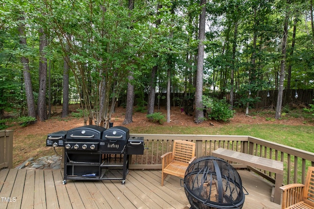 deck featuring an outdoor fire pit and fence