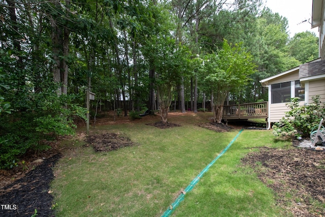 view of yard featuring a sunroom and a deck