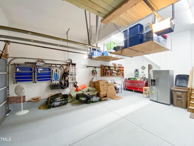 garage featuring a garage door opener and stainless steel fridge with ice dispenser