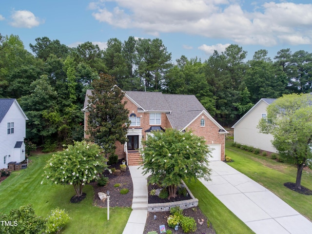 view of front facade featuring driveway, a front yard, and brick siding