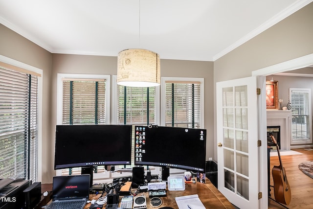 office featuring a fireplace with flush hearth, crown molding, and wood finished floors