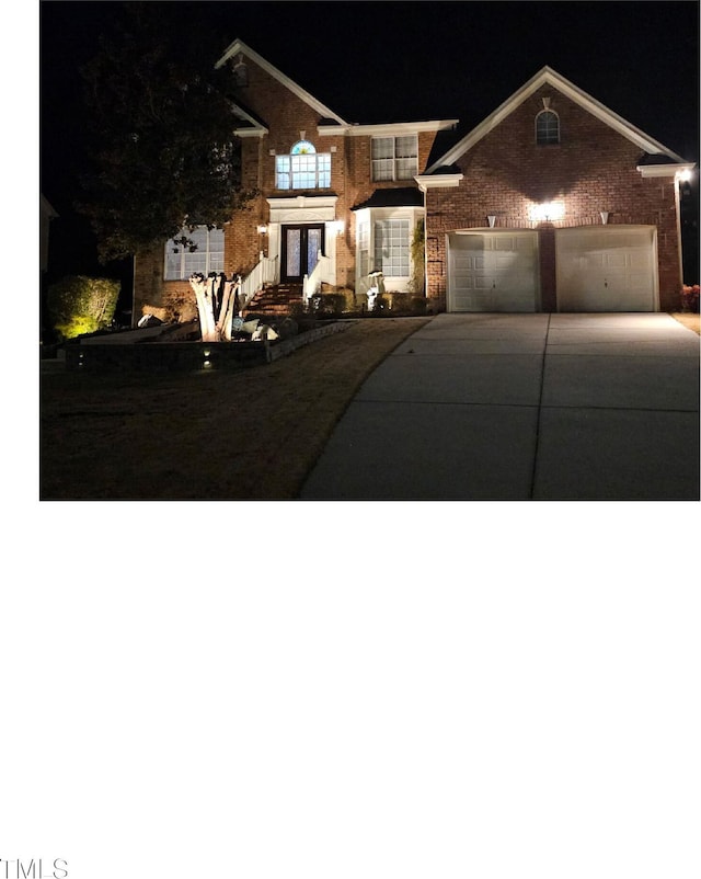 view of front of house with a garage, brick siding, and driveway