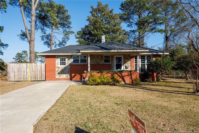 view of front of property featuring a front lawn, fence, and brick siding