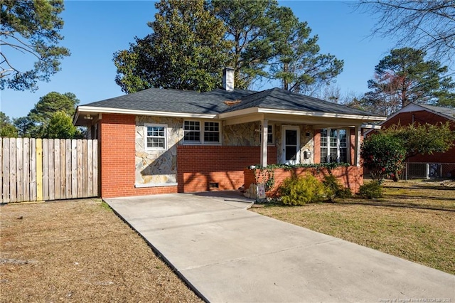 view of front facade with stone siding, brick siding, crawl space, and fence