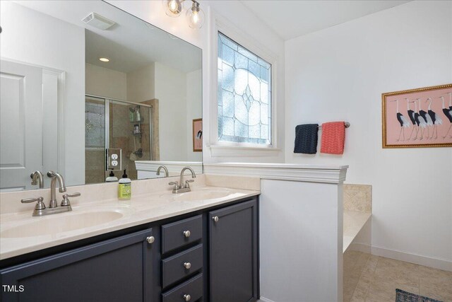 full bath featuring a shower stall, double vanity, visible vents, and a sink