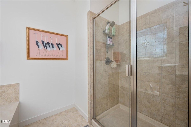 full bathroom featuring a shower stall and baseboards