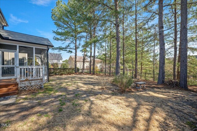 view of yard with a fenced backyard and a sunroom