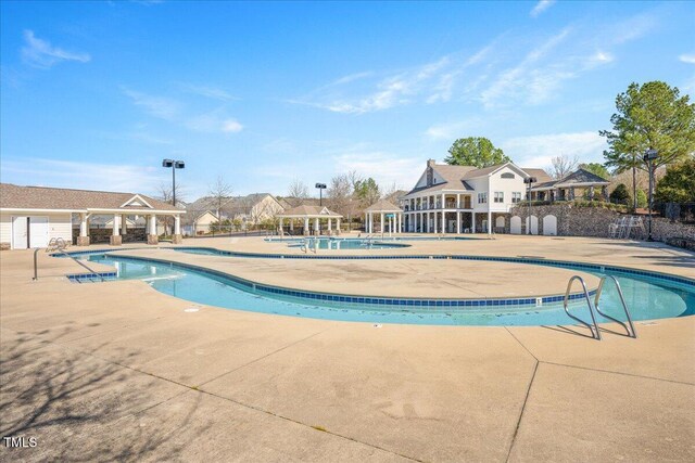 pool with a gazebo, fence, and a patio area