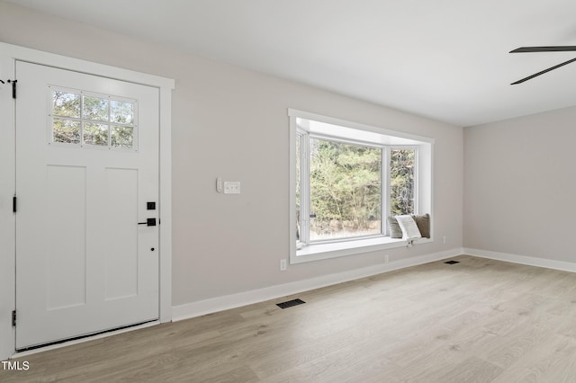 foyer entrance featuring visible vents, baseboards, light wood-type flooring, and ceiling fan