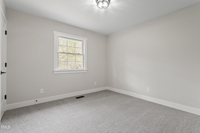 spare room with visible vents, baseboards, and carpet flooring