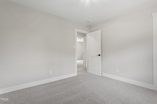 unfurnished room with baseboards and carpet