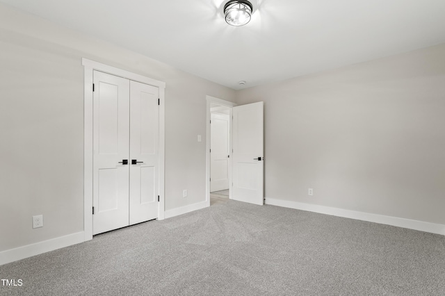 unfurnished bedroom with a closet, baseboards, and carpet floors