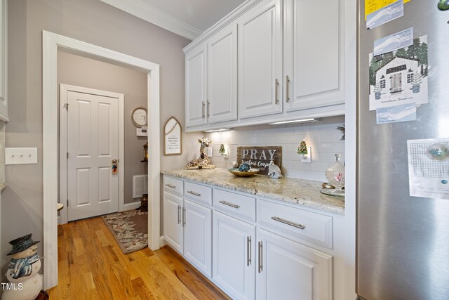 5204 Sandbridge Rd, Bailey, NC 27807 - kitchen featuring freestanding refrigerator, white cabinetry, light wood finished floors, backsplash, and ornamental molding