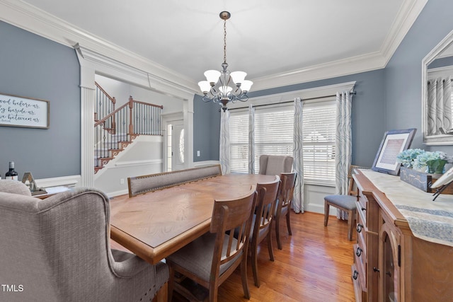 dining space with a chandelier, baseboards, stairs, light wood-type flooring, and crown molding