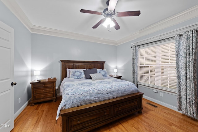 bedroom with baseboards, light wood-type flooring, visible vents, and crown molding