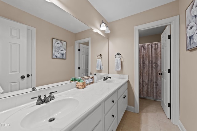 bathroom featuring double vanity, baseboards, a sink, and tile patterned floors