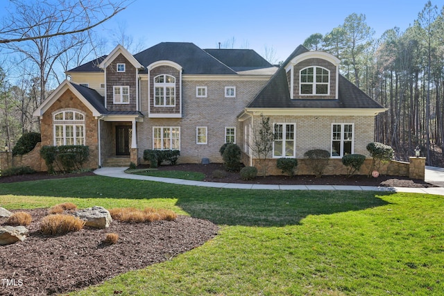 view of front of property with stone siding, brick siding, and a front lawn