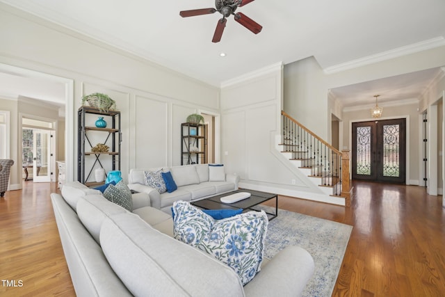 living area with a decorative wall, plenty of natural light, french doors, and stairs