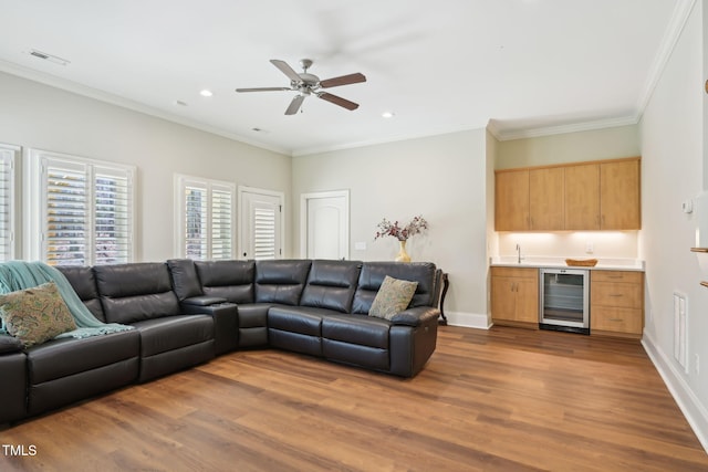 living room featuring visible vents, dark wood-type flooring, baseboards, wine cooler, and ornamental molding