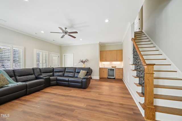 living room with wood finished floors, recessed lighting, stairway, wine cooler, and crown molding