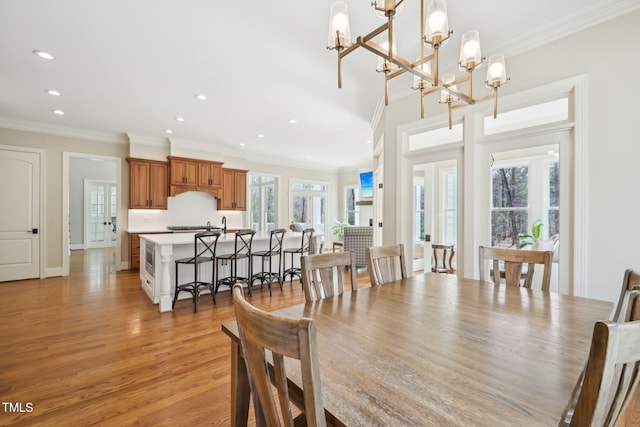 dining space featuring crown molding, recessed lighting, light wood-style floors, and baseboards