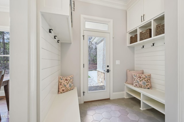 mudroom with light tile patterned floors, baseboards, and crown molding