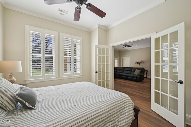 bedroom with visible vents, french doors, crown molding, and wood finished floors