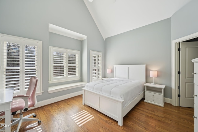 bedroom with baseboards, high vaulted ceiling, and wood finished floors