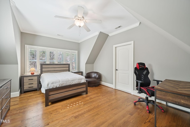 bedroom with light wood-type flooring, visible vents, baseboards, and crown molding