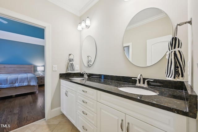 ensuite bathroom with tile patterned flooring, ornamental molding, double vanity, and a sink