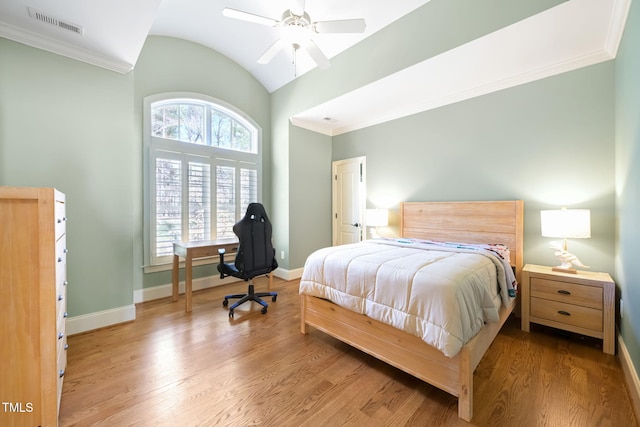 bedroom with visible vents, wood finished floors, baseboards, and lofted ceiling