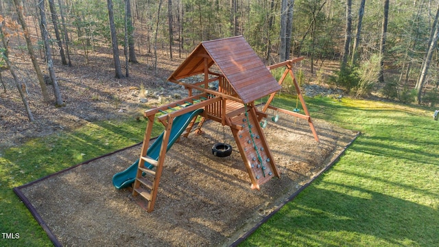 view of jungle gym with a view of trees and a lawn