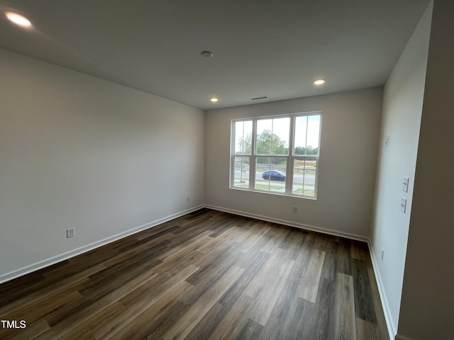 spare room featuring baseboards, recessed lighting, and dark wood-style floors