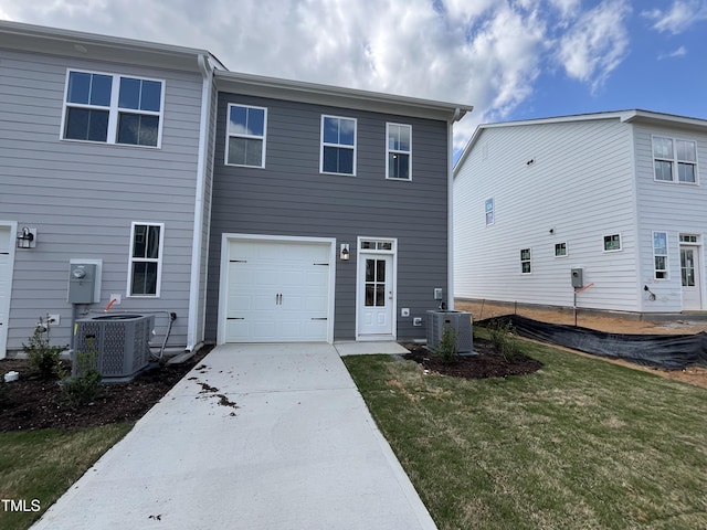 rear view of property with driveway, central AC unit, and a lawn