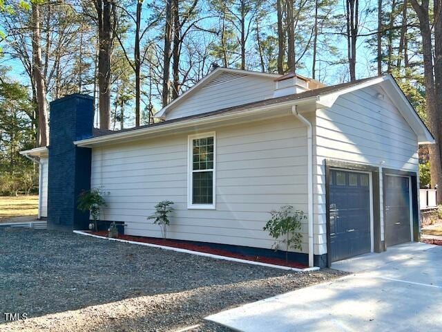 view of home's exterior featuring a garage and a chimney