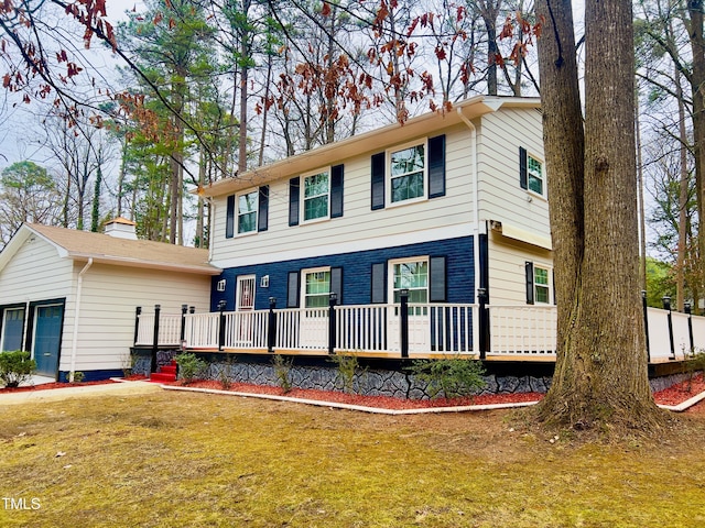 view of front of house featuring a front yard, brick siding, and a deck