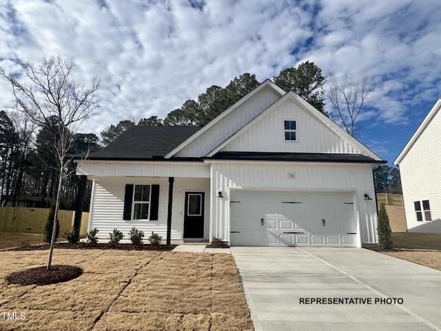 modern farmhouse style home with a garage, concrete driveway, fence, and a porch