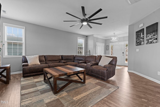 living area featuring visible vents, ceiling fan, baseboards, and wood finished floors