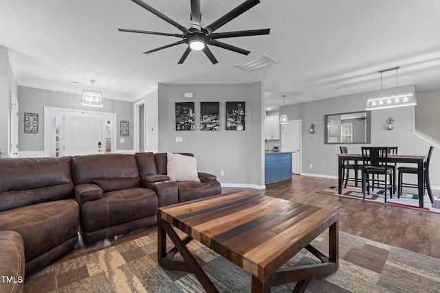 living room featuring crown molding, dark wood finished floors, baseboards, and a ceiling fan