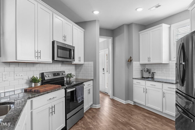 kitchen with white cabinets, visible vents, stainless steel appliances, and dark wood-style flooring