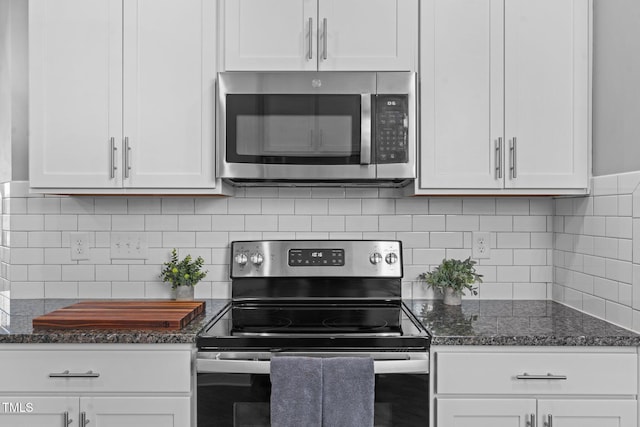 kitchen featuring dark stone counters, tasteful backsplash, appliances with stainless steel finishes, and white cabinets