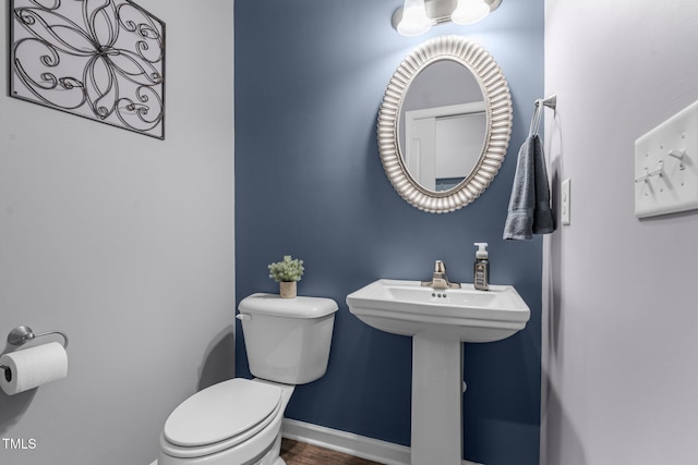 half bath with toilet and baseboards